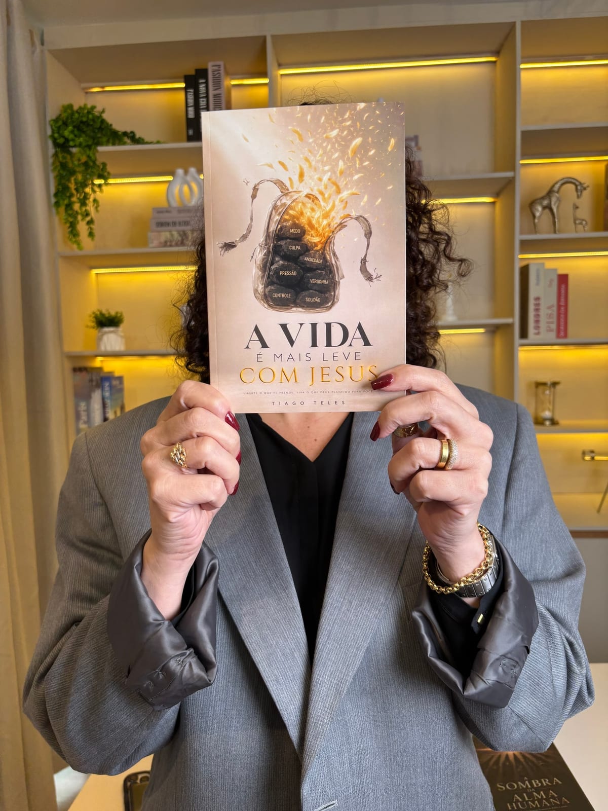 Leitora segurando o livro A Vida é Mais Leve com Jesus