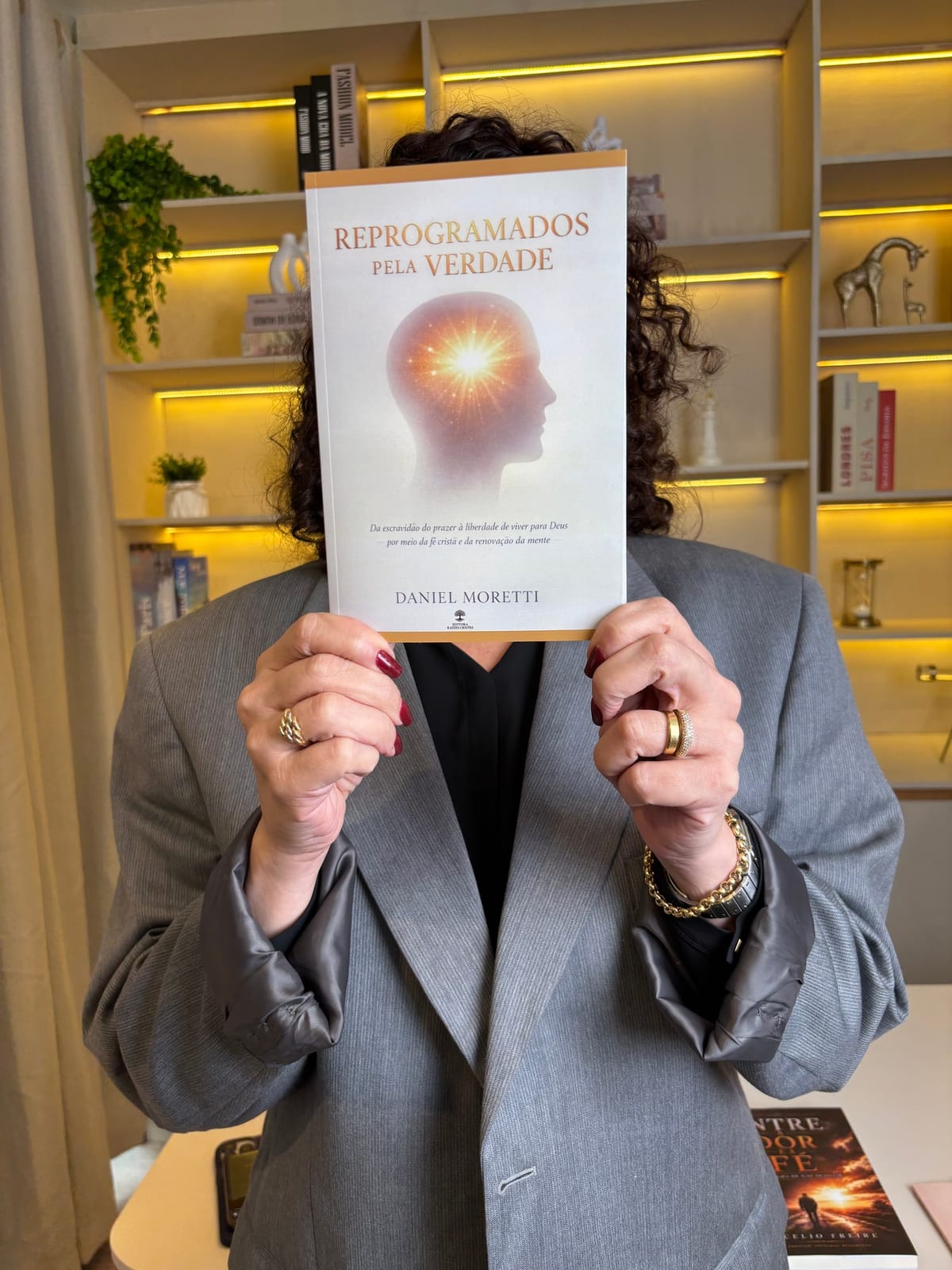 Leitora segurando o livro Reprogramados pela Verdade