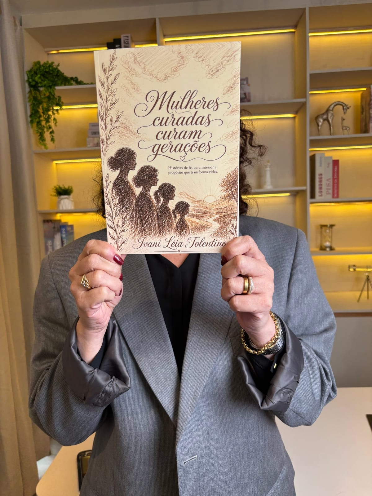 Leitora segurando o livro Mulheres Curadas Curam Gerações