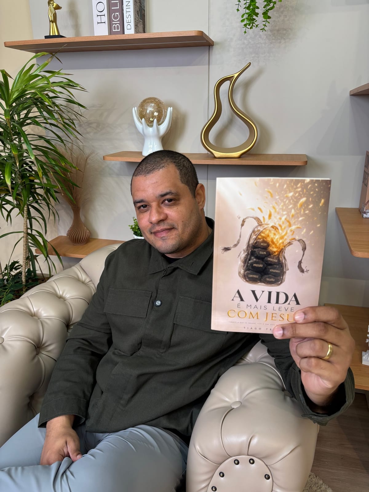 Tiago Teles segurando o livro A Vida é Mais Leve com Jesus